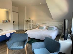 塞尔塞迪利亚勒克斯德尔波尼连酒店的一间卧室配有一张床、两把椅子和一个浴缸