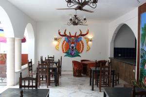 巴利亚多利德Hotel Casona Margot的用餐室配有桌椅,墙上挂有绘画作品