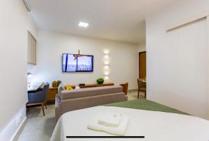 巴西利亚Kit Net Studio - II, moderna e aconchegante的一间卧室设有一张床和一间客厅。