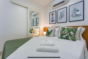 巴西利亚Kit Net Studio - II, moderna e aconchegante的一间卧室配有一张大床和两条毛巾