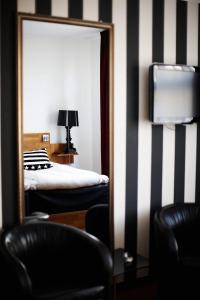 胡斯克瓦纳胡思克瓦纳城市酒店的配有一张床和电视的酒店客房内的镜子