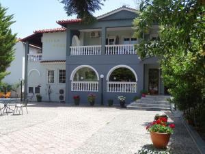 里托楚伦奥林匹斯山德罗索斯别墅酒店的蓝色和白色的房屋,设有庭院