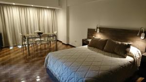 马德普拉塔Luminoso Ambiente, con cochera en lo mejor de La Perla的卧室配有一张床和一张桌子及椅子