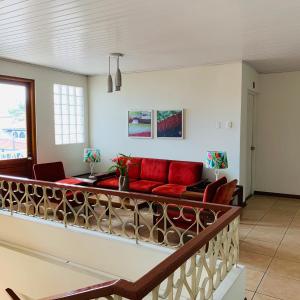 伊基托斯阿考斯塔酒店的阳台设有带红色沙发的客厅