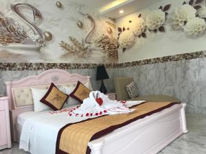 富国富国岛歌迪瓦酒店的卧室配有白色的床铺,墙上挂着鲜花