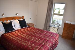 特威泽尔格莱斯顿小木屋度假屋的一间卧室设有一张大床和一个窗户。