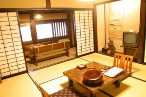 高山汤本朝哉日式旅馆的一间房间,内设桌子和电视