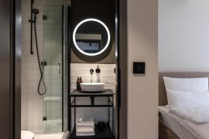 巴登-巴登THE ADAMS - Self Check In Hotel的一间带水槽和镜子的浴室