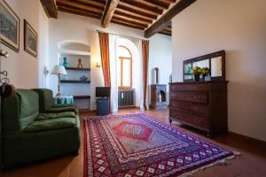 萨尔泰阿诺Albergo Santa Chiara的带沙发和电视的客厅以及地毯。