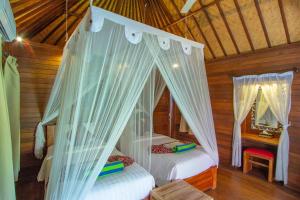 蓝梦岛Garden Cottage Lembongan & Hostel的木屋内设有一间带两张床的卧室