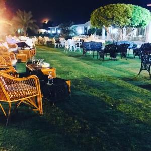 拉希迈尔汗Etihad Club by Faletti's Hotel的一群晚上在院子里的桌椅