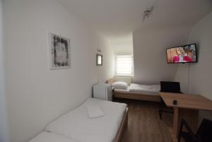 斯图加特AB Möhringen Messe Zimmer的客房设有一张床和一张桌子,墙上配有电视