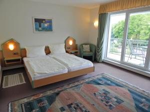 格罗尔斯泰因布鲁恩广场酒店的一间卧室设有一张床和一个大窗户