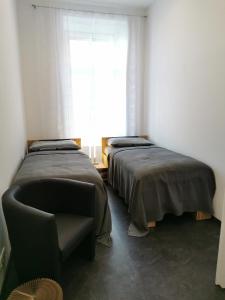 林茨FEWO am Neuen Dom的配有椅子和窗户的客房内的两张床