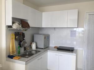 潘郎JACY Apartment - Phan Rang, Ninh Thuan的白色的厨房配有水槽和白色橱柜