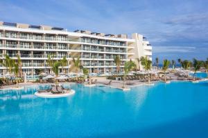 Spring RisesOcean Coral Spring Resort - All Inclusive的一个带棕榈树大型游泳池的度假酒店