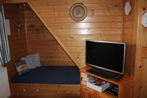 阿尔陶塞Ferienhaus Margotti的小木屋内带电视的小客房