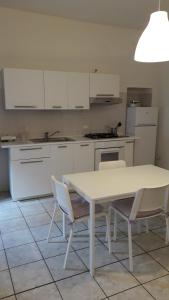 亚历山德里亚Appartamento A.D.的白色的厨房配有白色的桌子和椅子