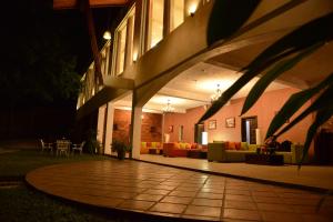 波隆纳鲁沃Agbo Hotel的一座带露台的建筑,晚上配有沙发