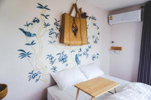 春武里帕投伊之家旅馆的卧室的墙壁上装饰着蓝色和白色的鲜花。
