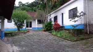 卡舒埃拉斯迪马卡库Pousada do Escultor的建筑物旁有砖砌车道的房子
