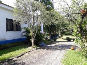 卡舒埃拉斯迪马卡库Pousada do Escultor的车道中间有树的房子