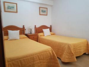 洛思坎加约斯Vivienda Vacacional la Palmera的配有黄色床单的客房内的两张床