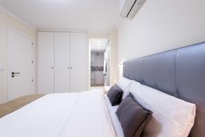马贝拉Beach Front Apartment-1st Line的一间卧室配有一张白色大床和蓝色床头板