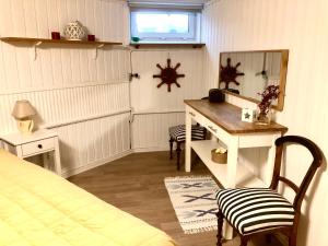 法尔肯贝里Lägenhet i Falkenberg的一间卧室配有书桌、一张床和镜子