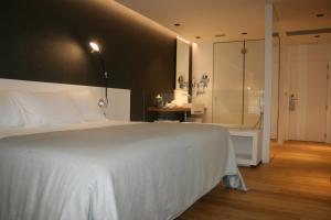 比韦罗Hotel U Viveiro的卧室配有白色的床和淋浴