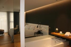 比韦罗Hotel U Viveiro的一间带一张床和浴缸的浴室