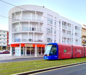 拉拉古纳NORASUITES32的一座建筑物前的红色和蓝色火车
