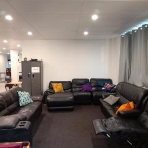 珀斯Perth City Backpackers Hostel - note - Valid passport required to check in的客厅配有黑色皮沙发