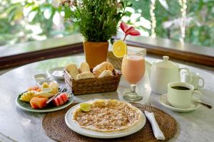 乌布Kebun Indah Ubud的餐桌,早餐包括煎饼、面包和饮料