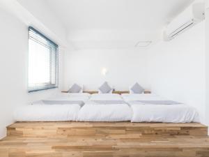 横须贺市Mykonos Resort Miura / Vacation STAY 62208的一间白色卧室,配有两张床和窗户