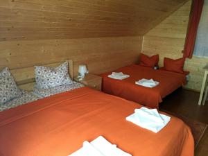 Păuleni-CiucNimfa Apartments的配有橙色床单的客房内的两张床