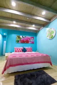 MataveraShineAwayHomes -AC Beachfront RAROTONGA的一间卧室设有一张床和蓝色的墙壁