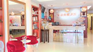 台东中华典藏商旅的餐厅设有红色的椅子、桌子和柜台