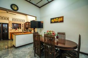 科伦坡Leo's Home Stay的一间带桌子和电视的用餐室