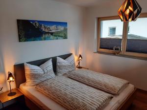 齐勒谷地施特拉斯Apart Alexandra的卧室配有带枕头的床铺和窗户。