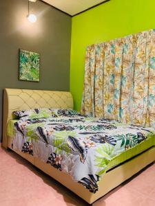 瓜拉丁加奴Ammar Homestay的绿色墙壁间的一张床位