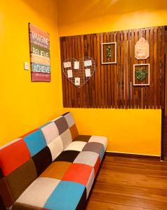 瓜拉丁加奴Ammar Homestay的黄色墙壁的房间里一张沙发