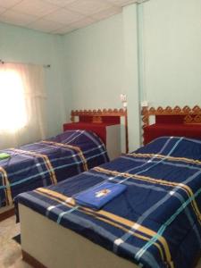Ban Huai SalokWangtong Resort 2的配有两张蓝色和黄色床单的客房