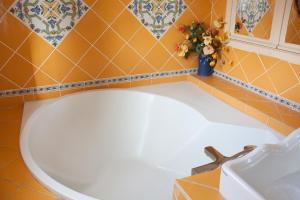 土伦佩契尔庄园旅馆的浴室设有白色浴缸和花瓶