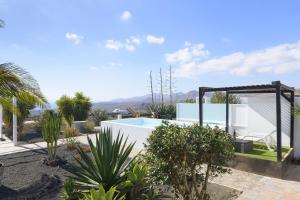 蒂亚斯Casa Amanecer的一座别墅,设有游泳池和棕榈树