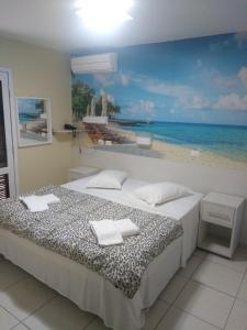 瓜拉图巴Hotel Rota do Sol的一间卧室配有一张海滩绘画床