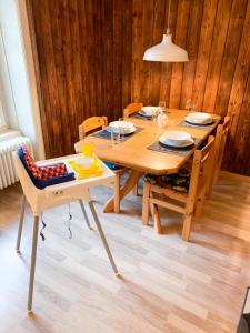 迈林根Ferienwohnung Meiringen "Engelhorn"的一张带椅子的木桌和木墙