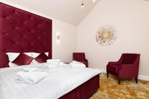 塔林Hotel Meltzer Apartments的一间卧室配有一张带红色床头板的床和两把椅子