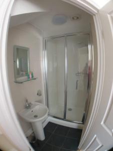 韦茅斯4 Bedroom House的带淋浴和盥洗盆的白色浴室