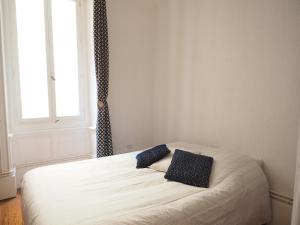 瓦朗斯Appartement le st jean - centre historique的一间卧室配有一张带两个蓝色枕头的床